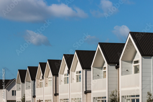 Fototapeta row of white houses against blue sky