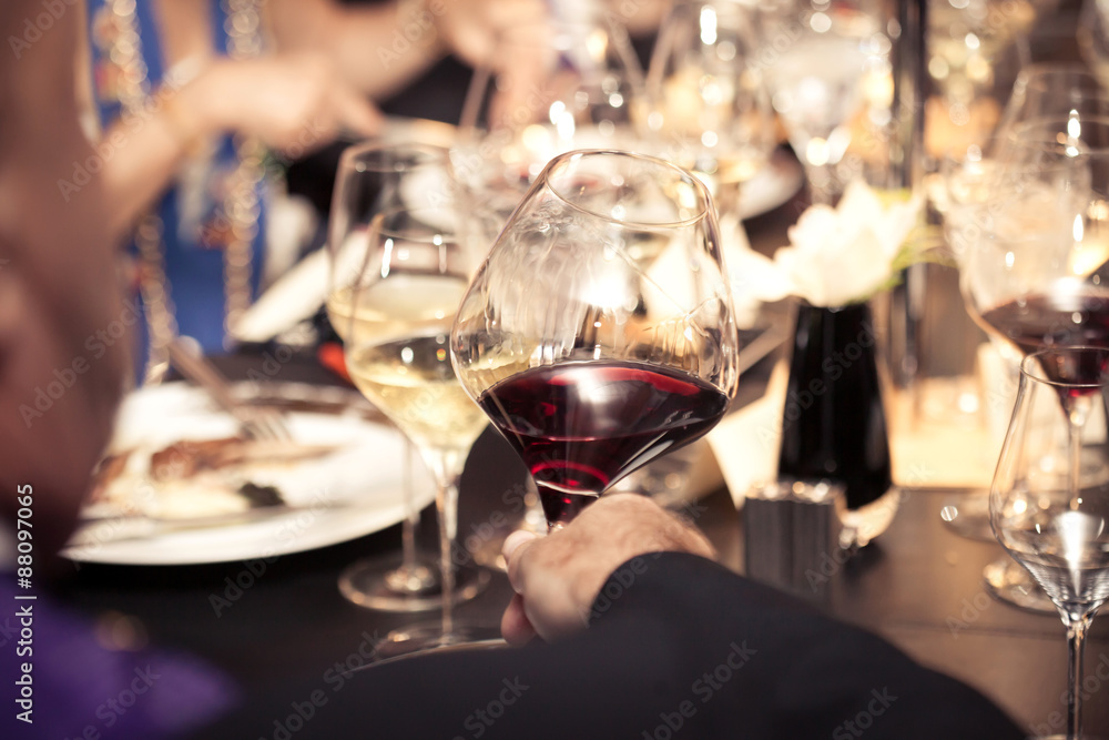 Obraz premium red wine on hand with dinner on restaurant