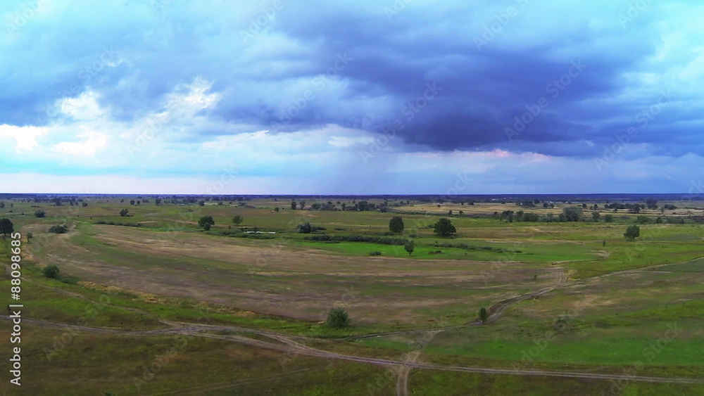 Flight in field and storm clouds with rain on a distance shot.Aerial
Flight in field and storm clouds with rain on a distance shot.Aerial