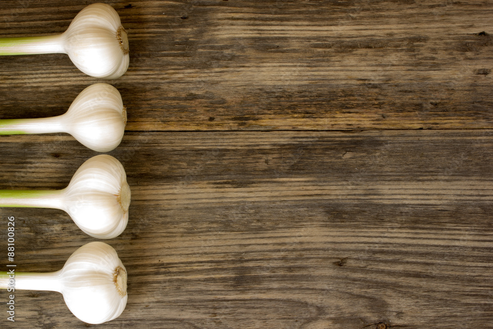 fresh garlic bulbs with long stalk on wood table with copy space fresh garlic bulbs with long stalk on wood table with copy space