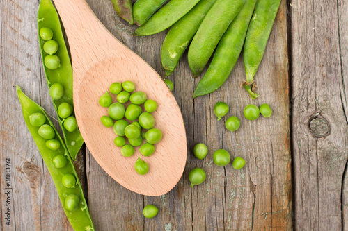 Freshly picked green peas on a wooden table.