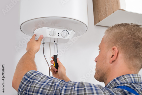 Worker Fixing Electric Boiler