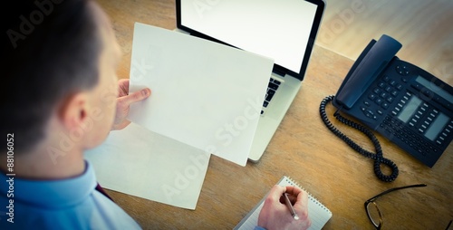 Focused businessman reading document at desk