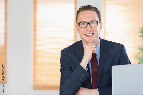 Happy businessman sitting at his desk