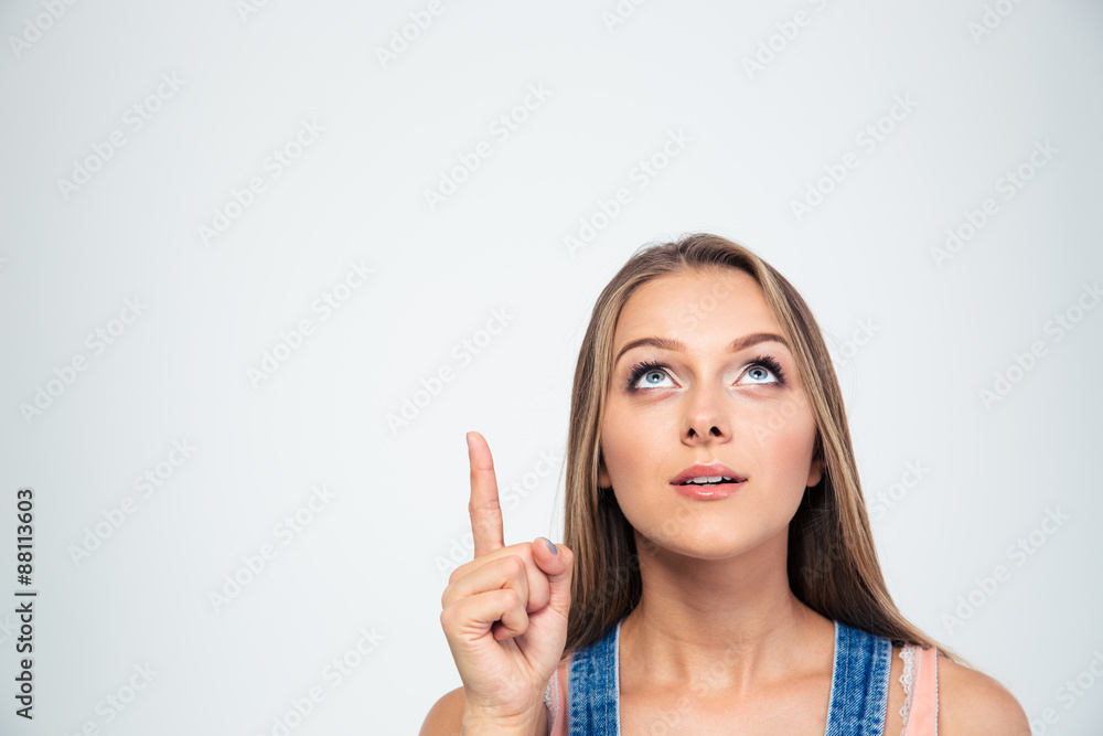 Thoughtful woman pointing finger up at copyspace Thoughtful woman pointing finger up at copyspace