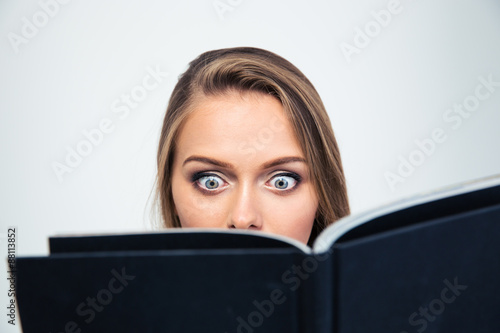 Amazed young woman reading book