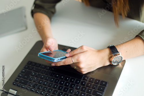 Business woman working with mobile phone in her office.