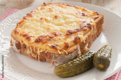 Croque Monsieur a French grilled cheese and ham sandwich served with pickles