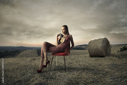 Beautiful woman sitting in a chair in the countryside