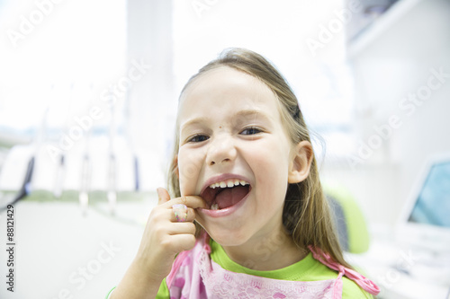 Obraz na płótnie Girl showing her healthy milk teeth at dental office w salonie