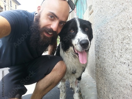 bearded man and his friend pet dog outdoor in the street taking selfie