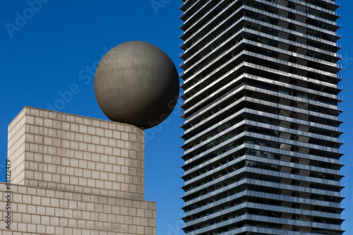 Spherical sculpture and detail of skyscrapers that generate an optical effect in Barcelona