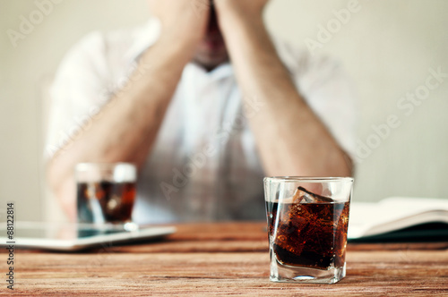 glass of whiskey with cola on a wooden table