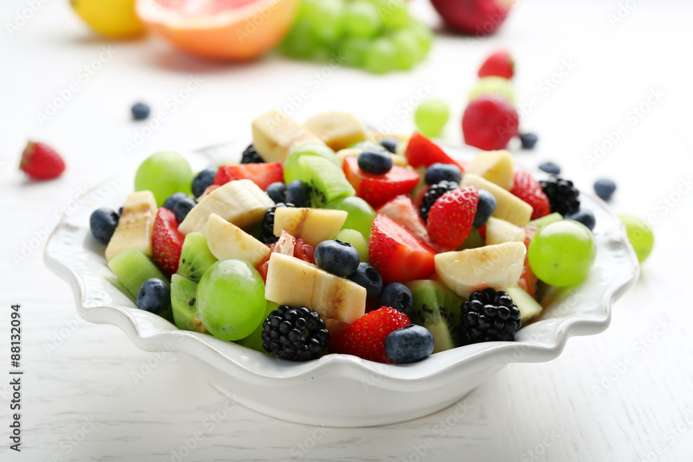 Fresh fruit salad on white wooden table Fresh fruit salad on white wooden table