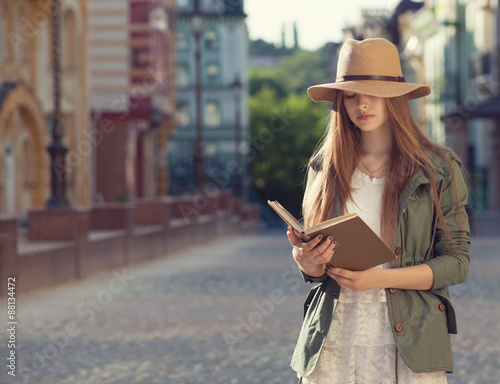 Yuccie girl reading book outdoors photo