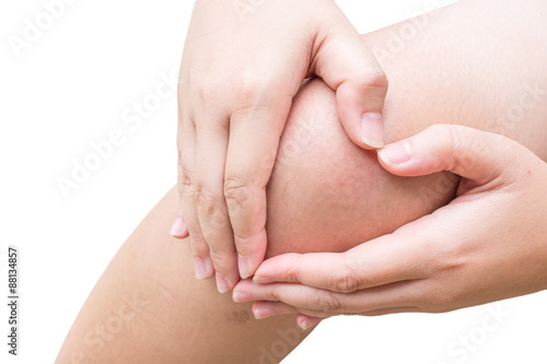 Woman hand touch on pain knee with isolated background. © Pawinee