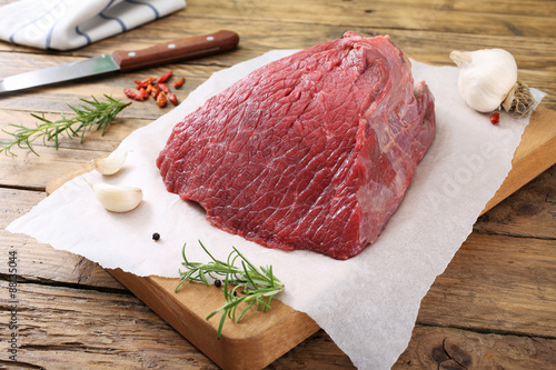 carne cruda filetto di manzo con spezie su tagliere sfondo rustico