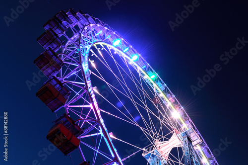 Ferris wheel with multi-colored illumination against night sky