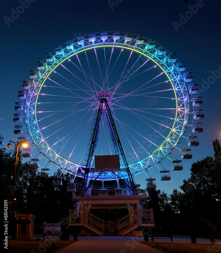 Ferris wheel with multi-colored illumination against night sky