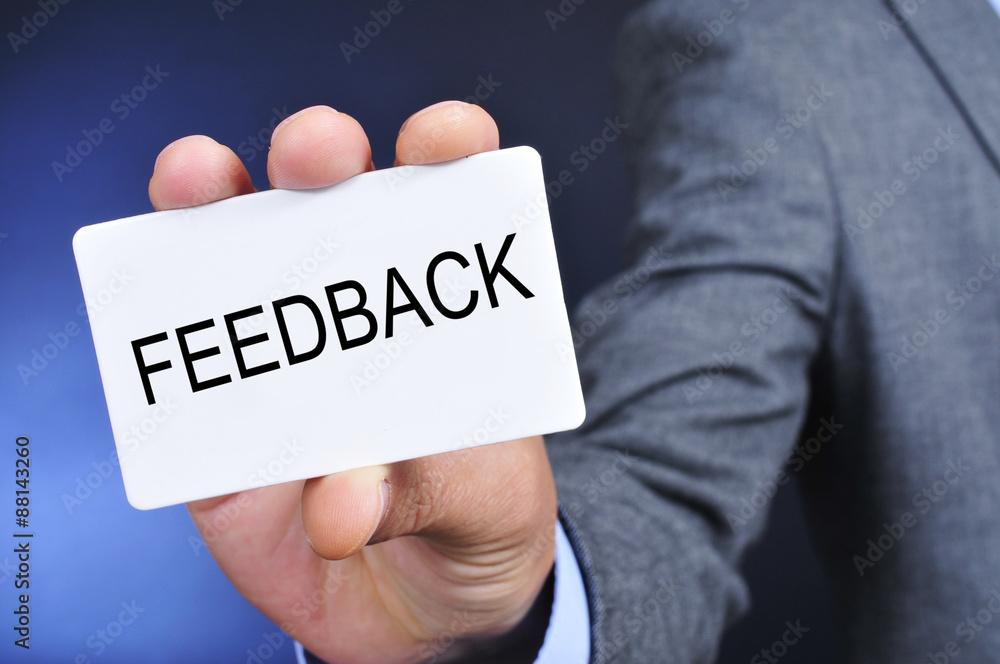 man in suit shows a signboard with the word feedback man in suit shows a signboard with the word feedback