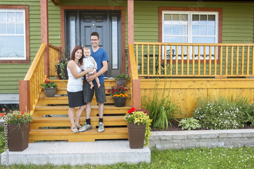 Canvas Print Portrait of couple with their adorable daughter in front of house