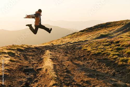Man jumping over mountain road on sunrise