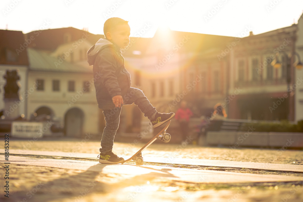 Child with skateboard on the street at sunset light. Child with skateboard on the street at sunset light.