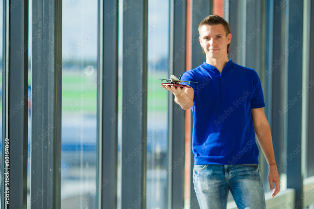 Young caucasian man holding passports and boarding pass at Young caucasian man holding passports and boarding pass at