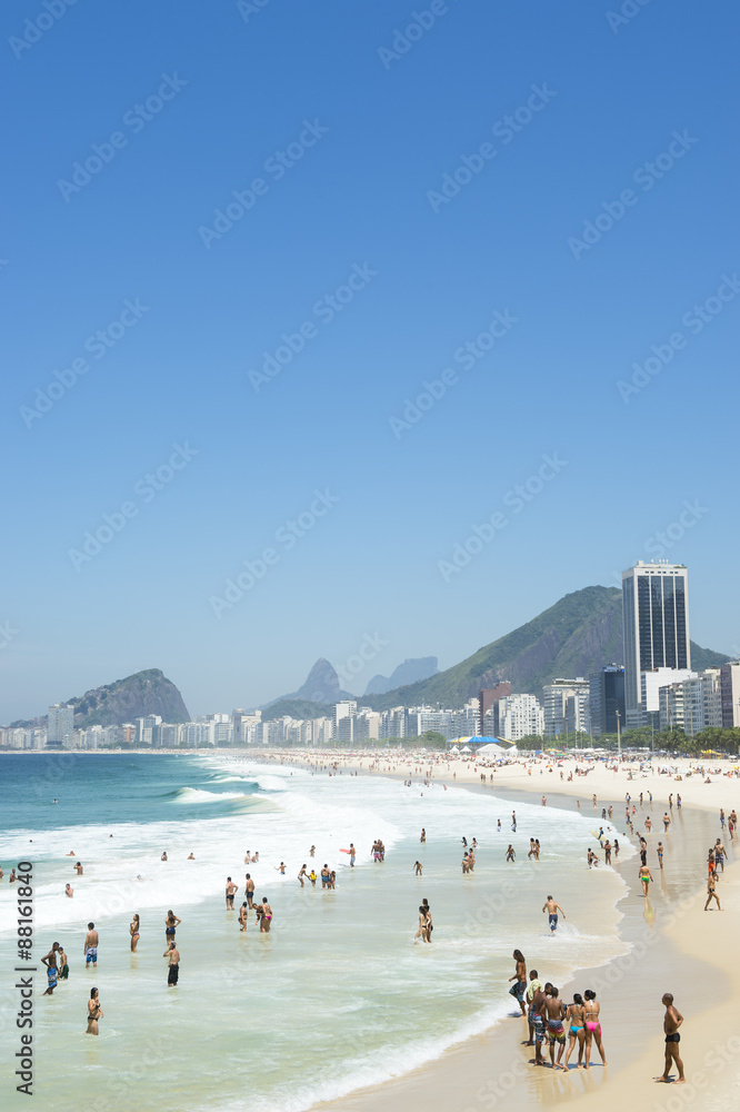 Beachgoers line the shore of Copacabana Beach on a bright summer morning in Rio de Janeiro, Brazil Beachgoers line the shore of Copacabana Beach on a bright summer morning in Rio de Janeiro, Brazil