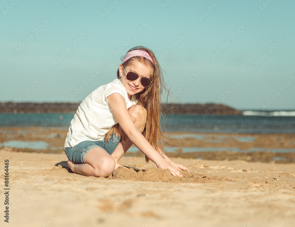 Fototapeta premium little girl in a hat on the beach