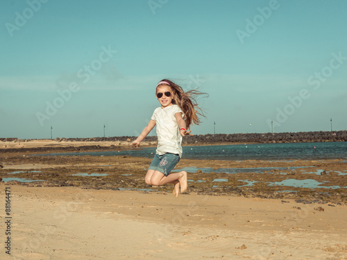 little girl jump on a beach