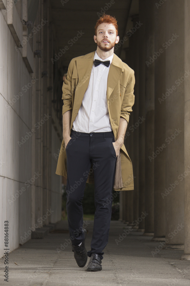 Fashionable red haired model posing outdoors, walking, full body Fashionable red haired model posing outdoors, walking, full body