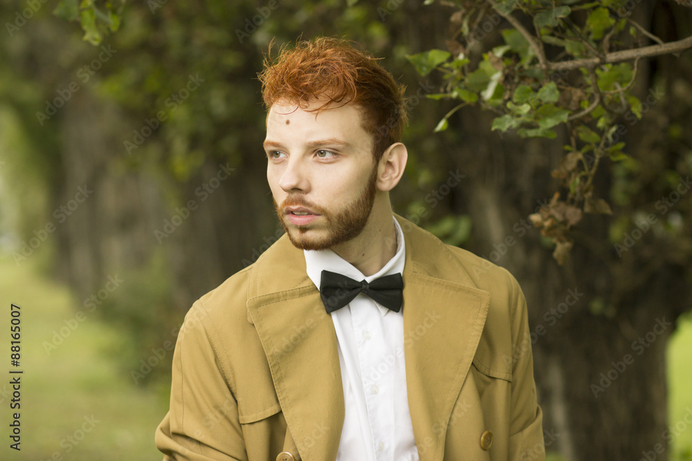 Fashionable red haired model posing in park, close up. Fashionable red haired model posing in park, close up.