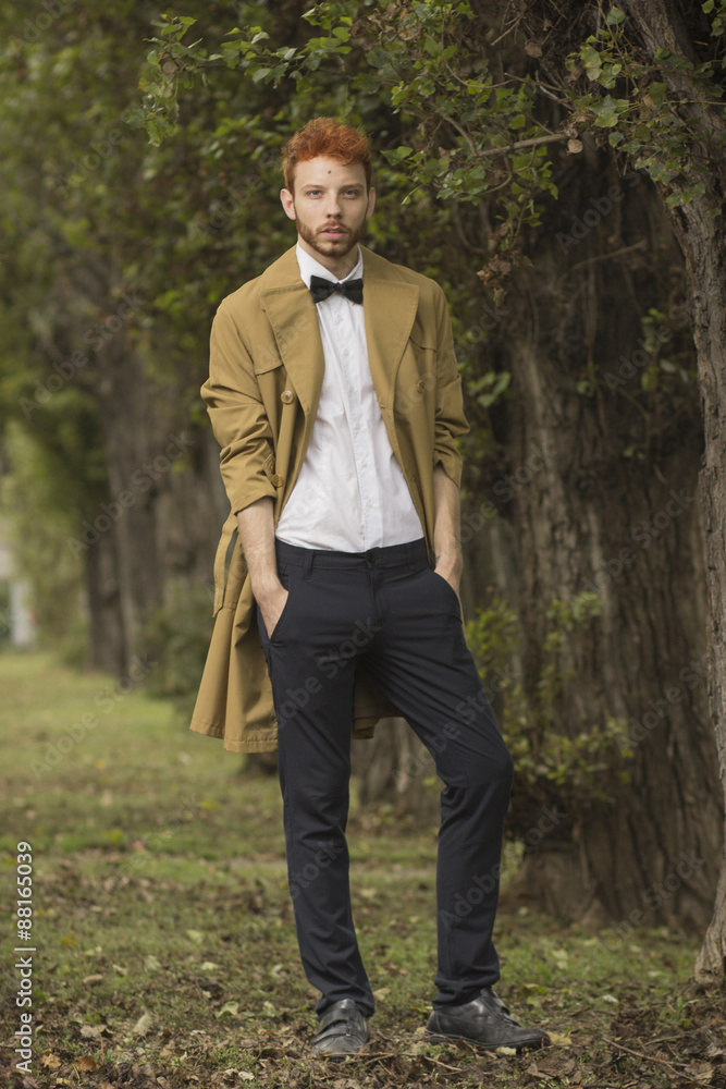 Fashionable red haired model posing in park. Fashionable red haired model posing in park.