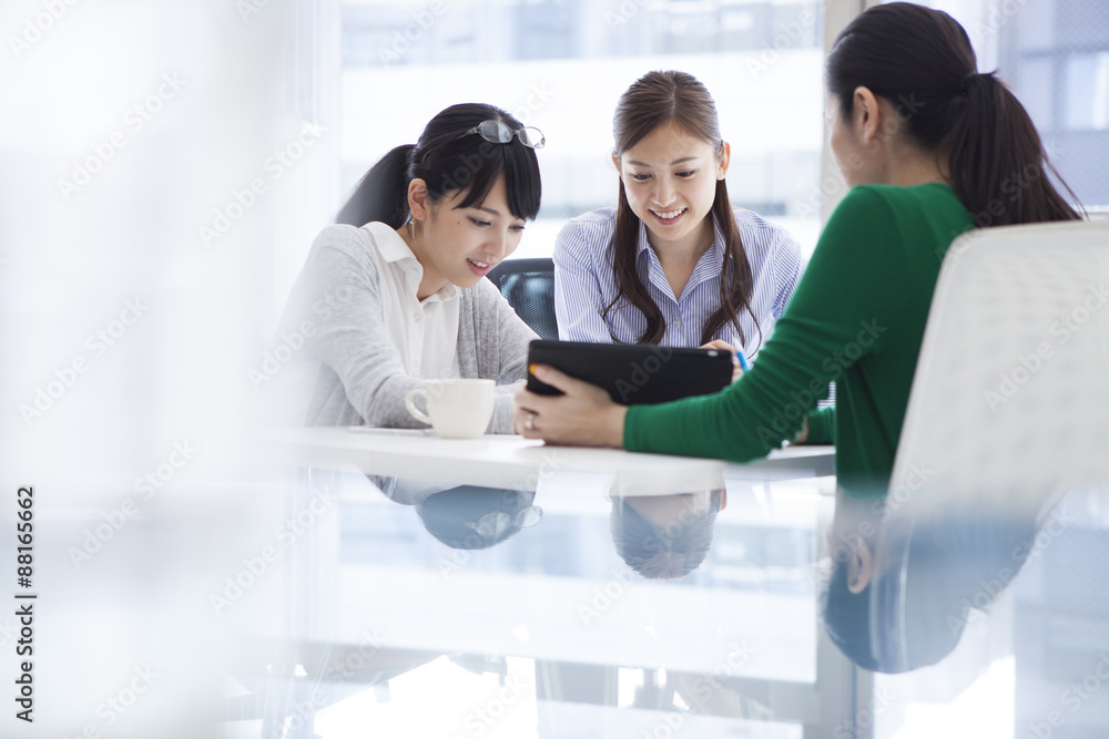 Three people that conversation while watching the tablet Three people that conversation while watching the tablet