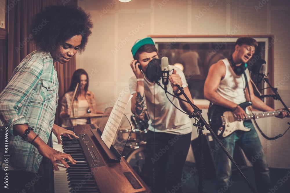Obraz premium Multiracial music band performing in a recording studio