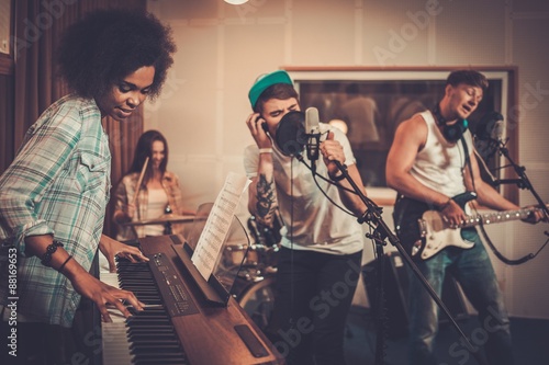 Multiracial music band performing in a recording studio