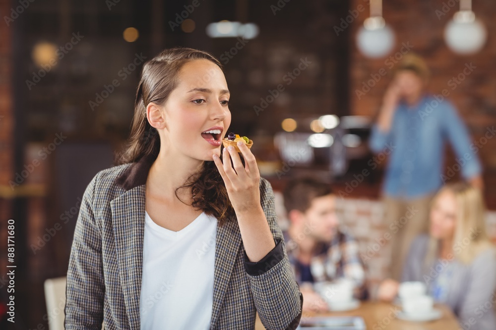 Smiling young woman eating muffin Smiling young woman eating muffin