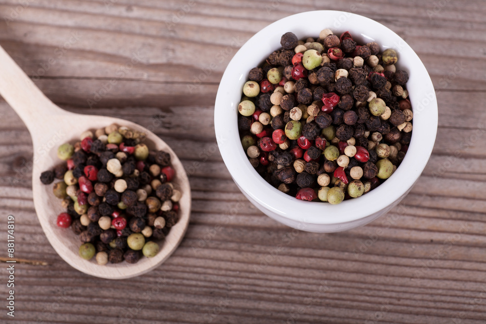 Pepper mixture on spoon over wooden background Pepper mixture on spoon over wooden background