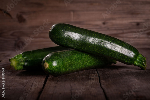 Fotografi green Zuchinis on wooden table