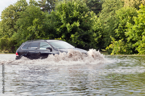 Tableau sur toile Car trying to drive against flood on the street in Gdansk, Poland