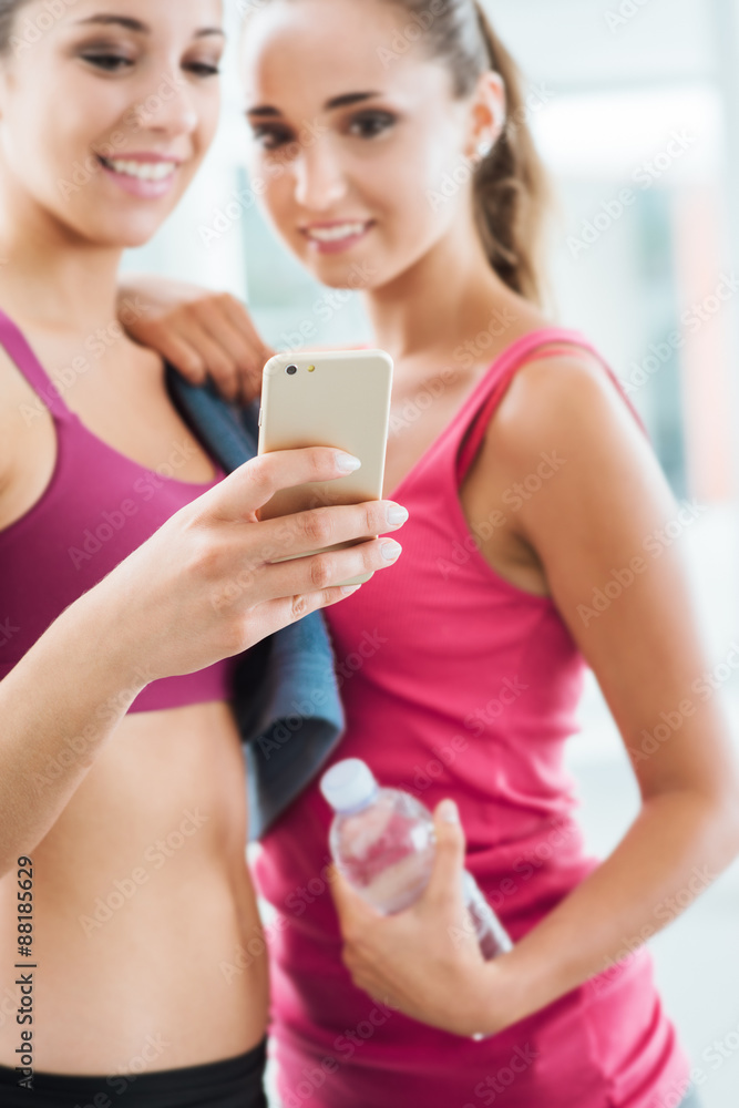 Happy girls using a fitness app Happy girls using a fitness app