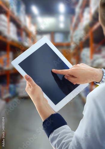 Businesswoman checking inventory in market on tablet computer photo