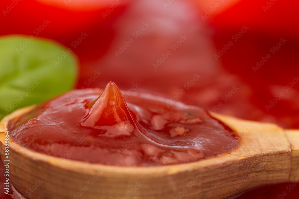 Tomato ketchup in a wooden spoon. Homemade, healthy vegetarian food