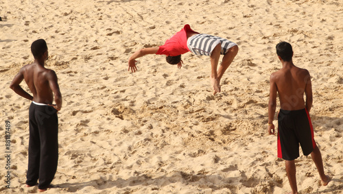 Jóvenes practicando Acrobacias en la playa