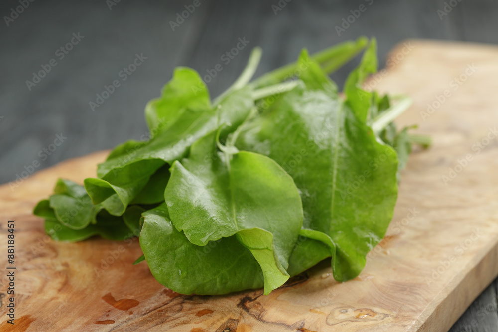 fresh sorrel leaves on cutting board on oak wood table fresh sorrel leaves on cutting board on oak wood table