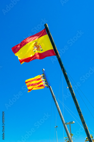 Flags of Valencia and Spain against blue sky photo