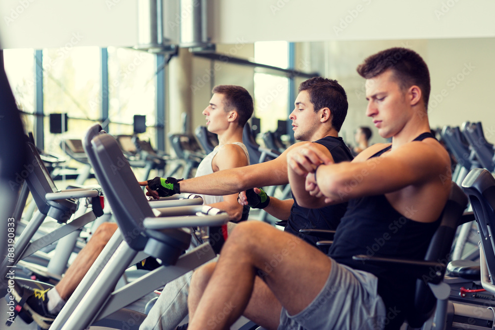 men working out on exercise bike in gym men working out on exercise bike in gym