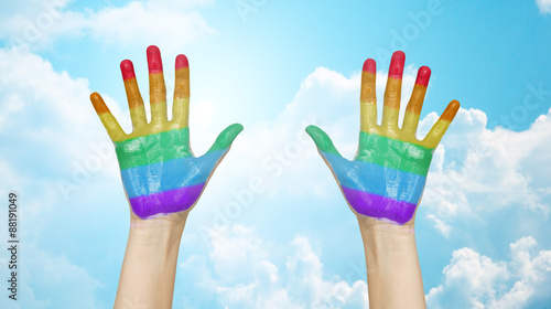 palms of human hands painted in rainbow colors