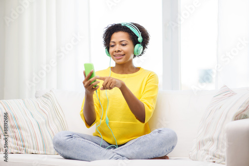 happy african woman with smartphone and headphones